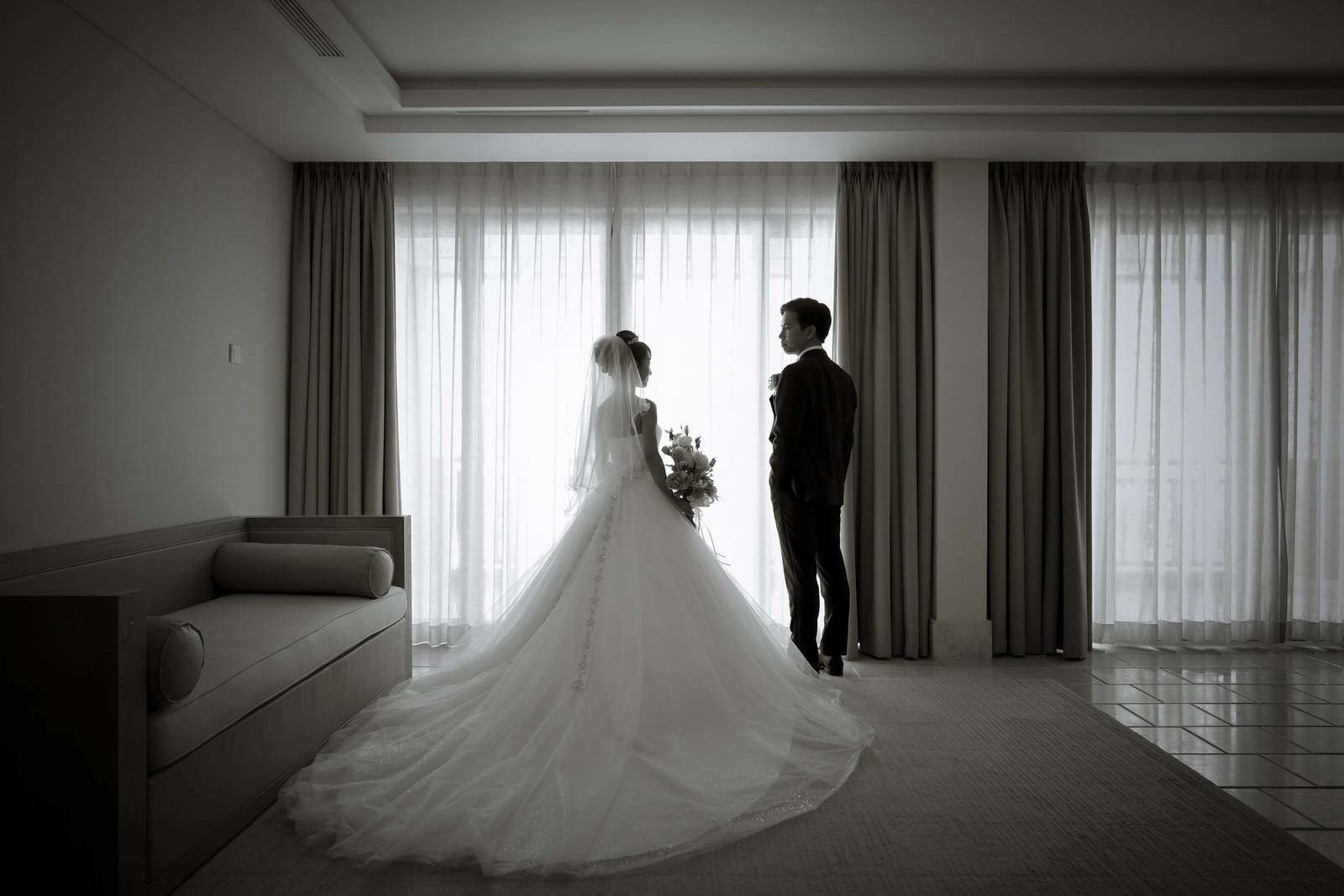 カーテンから外を眺める後ろ姿